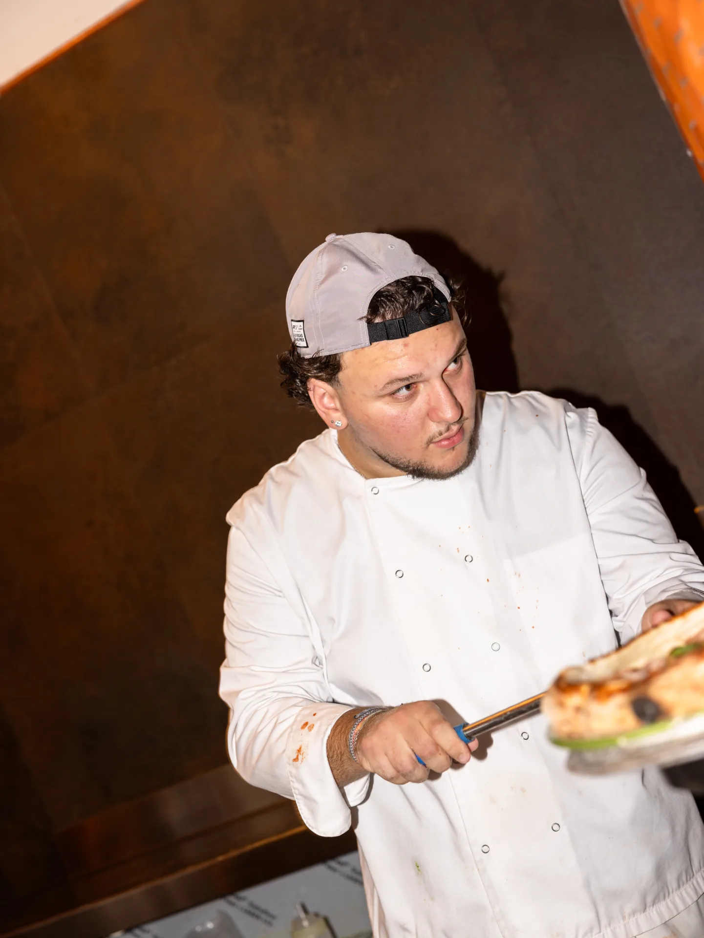 Lo chef prepara una pizza al forno