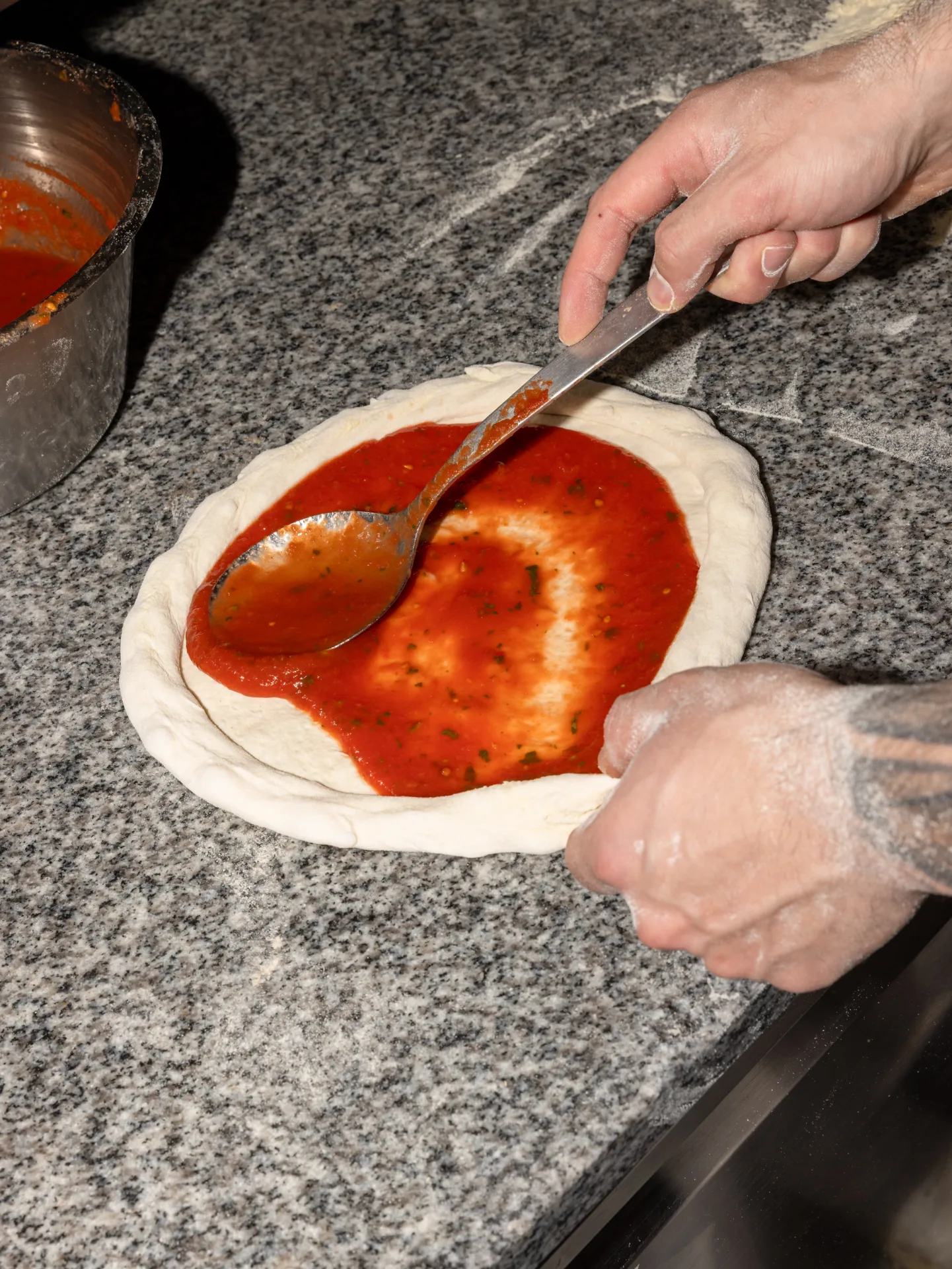 Preparazione della pizza con salsa di pomodoro