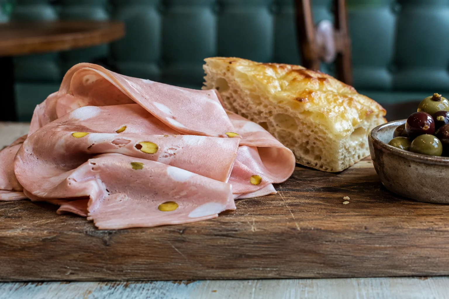 Tranches fines de Mortadella Bologna servies sur une planche en bois