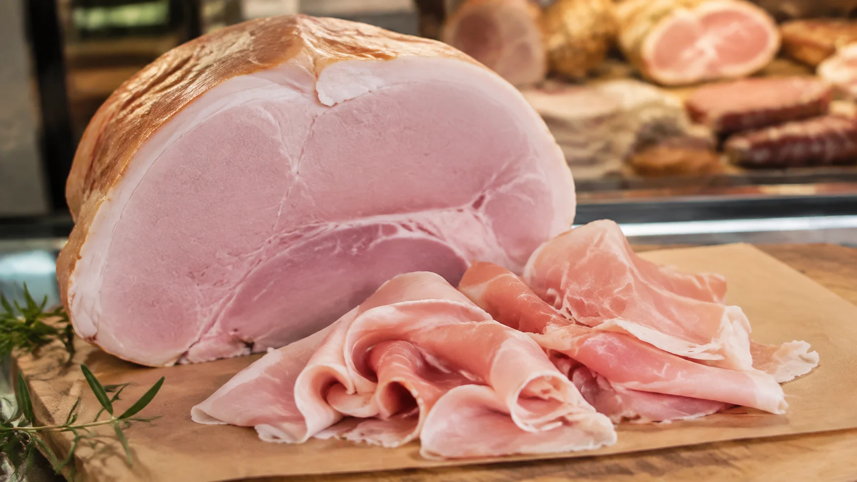 Tranches fines de prosciutto cotto sur planche en bois