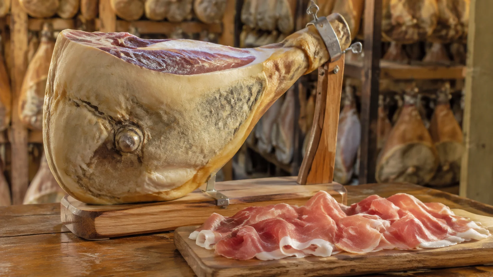 Tranches fines de Prosciutto di Parma sur planche en bois