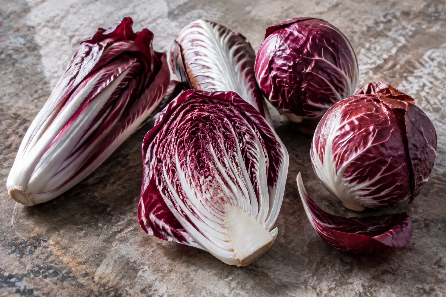 Radicchio italien aux feuilles rouges avec nuances blanches, posé sur un fond rustique