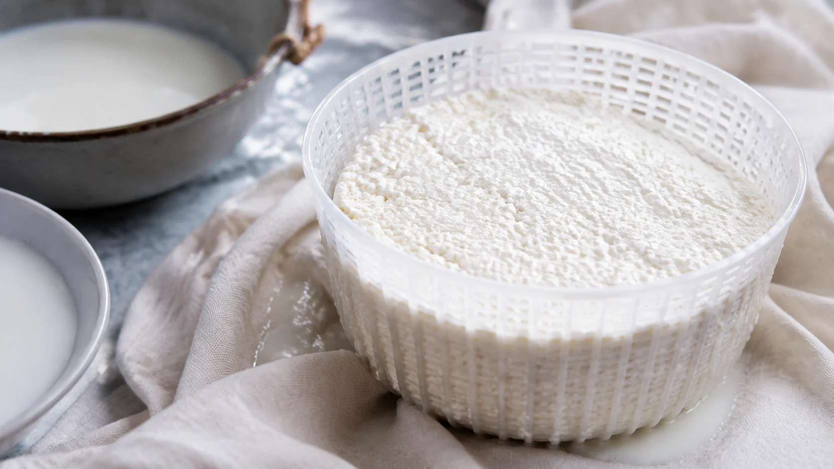 Bol de ricotta fraîche italien sur une planche en bois